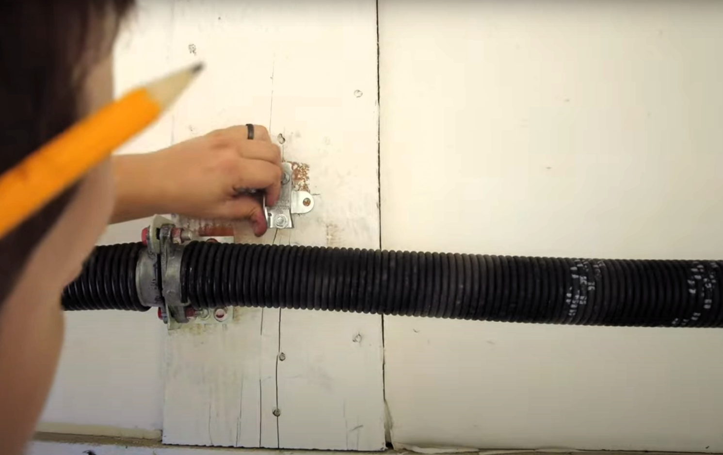Technician performing garage door spring repair on a residential garage door, ensuring proper alignment and functionality.