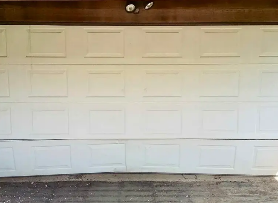 Technician performing garage door panel repair on a residential garage door, ensuring smooth operation and restored appearance.