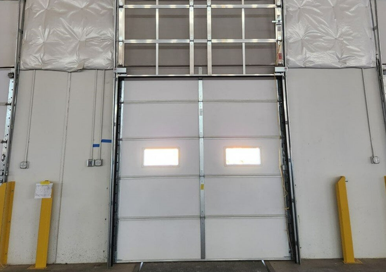 Technician performing overhead garage door repair on a residential property, ensuring proper alignment and functionality."