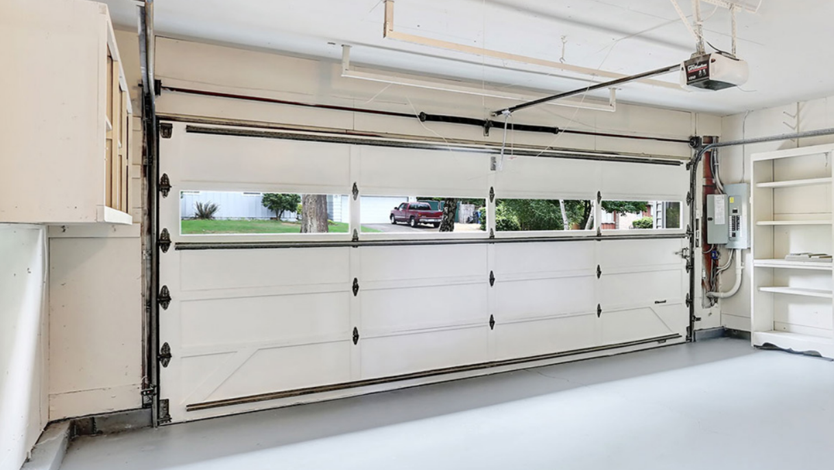 Technician performing same-day garage door repair on a residential garage, showcasing professional tools and expertise.