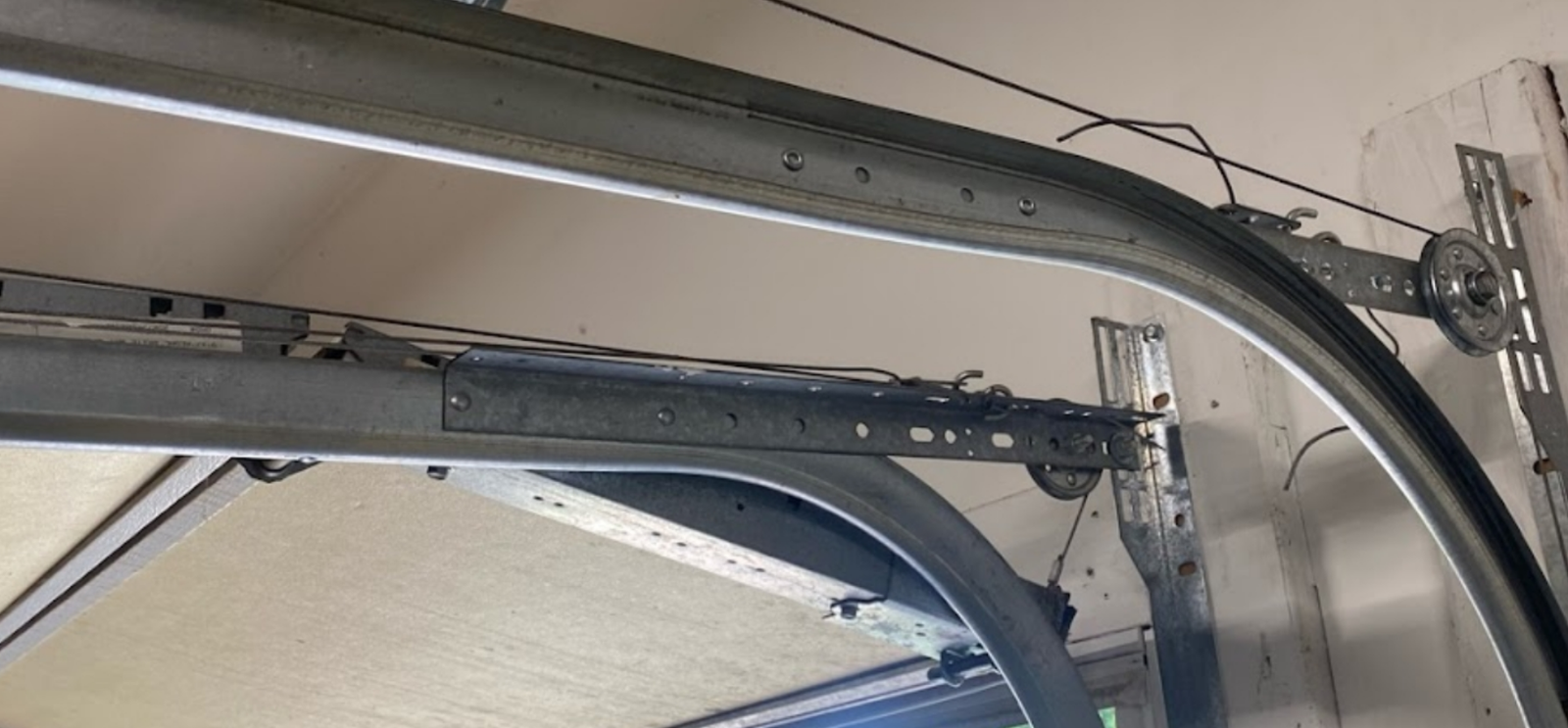 Technician performing garage door track repair to ensure smooth and secure operation.