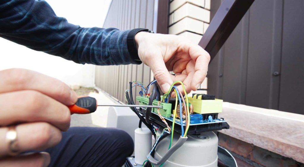 An image showing a technician repairing a residential gate, emphasizing professional gate repair services for increased home security.